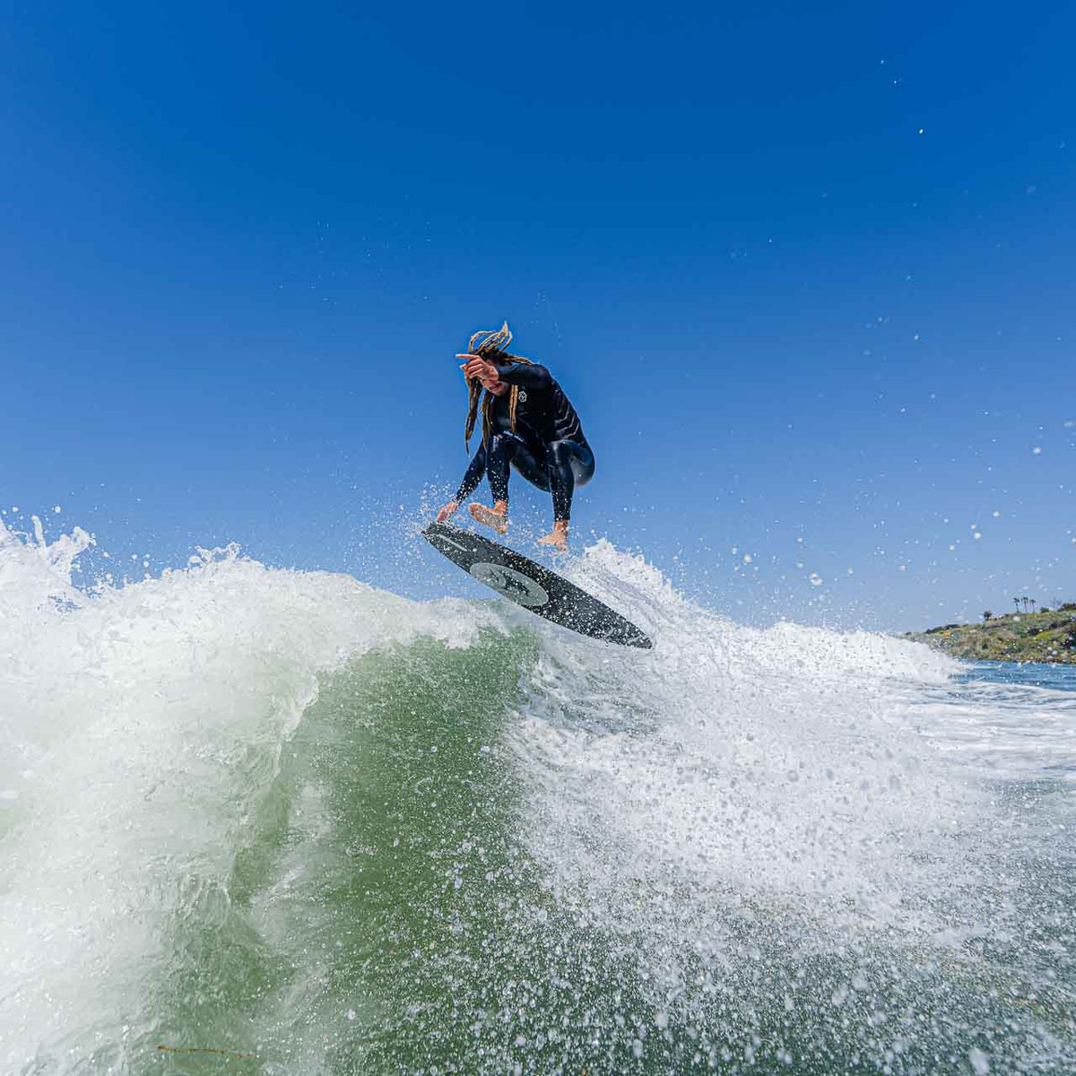 Austin Keen mid air on a Rusty Wakesurf Pro Skimboard with board in the air spinning