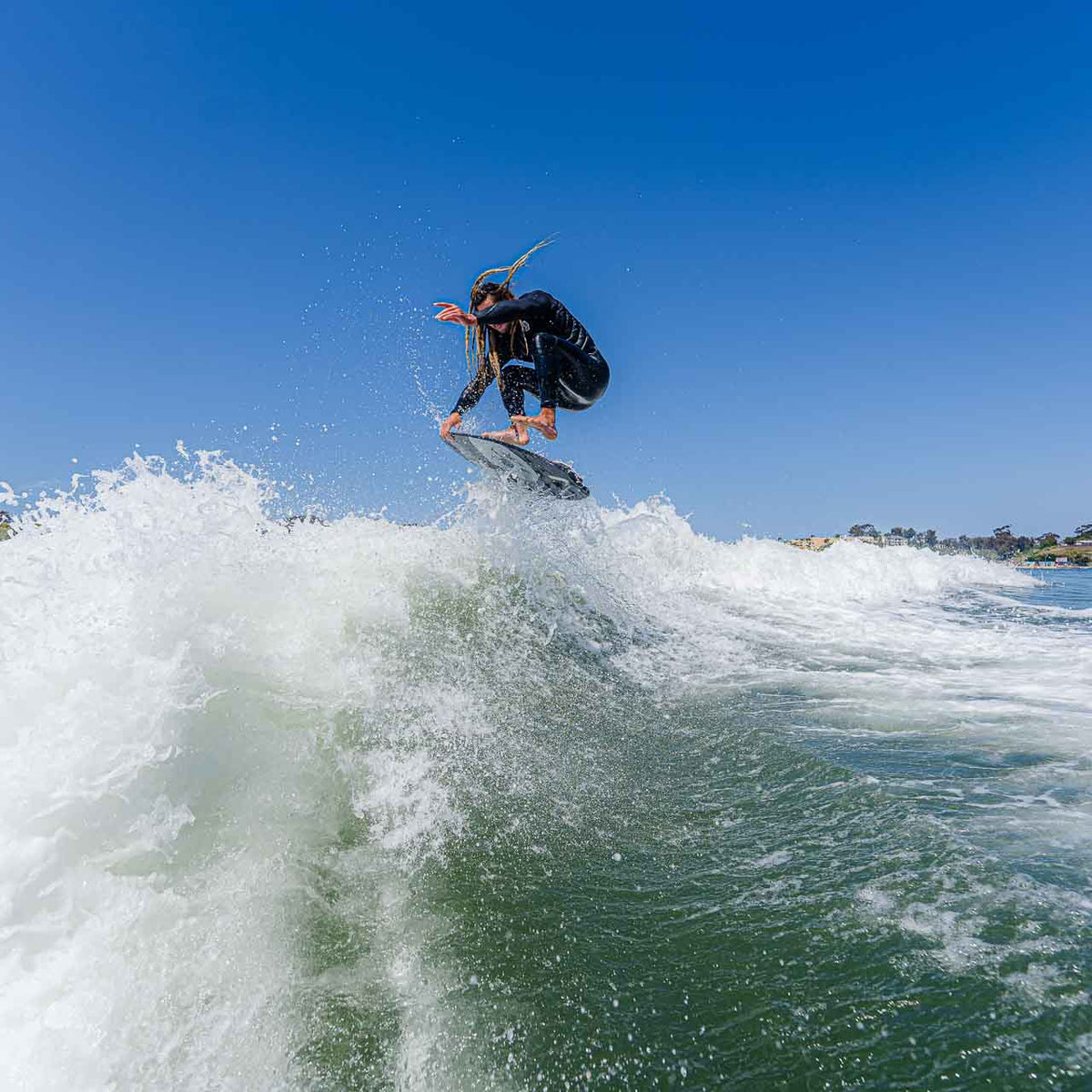 Austin Keen in the water boosting his pro skimboard